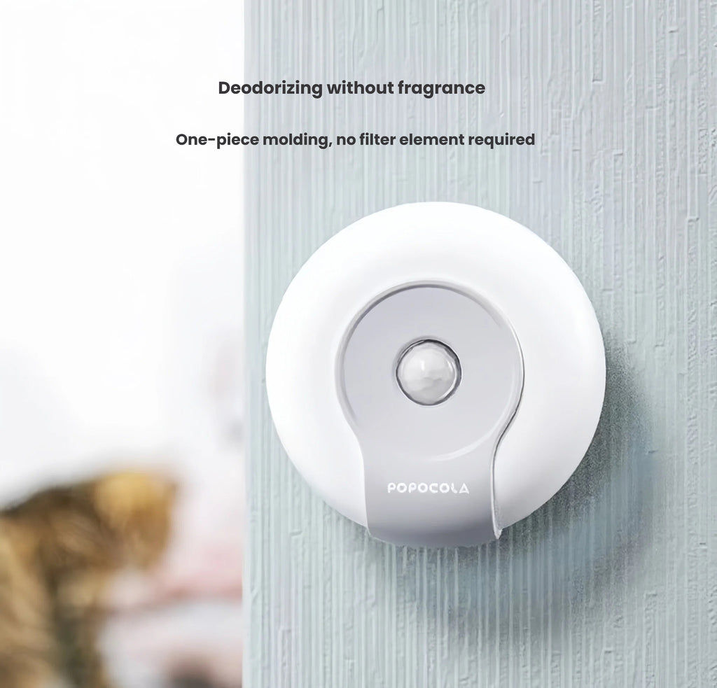 Wall-mounted Popocola litter deodoriser positioned near a cat
