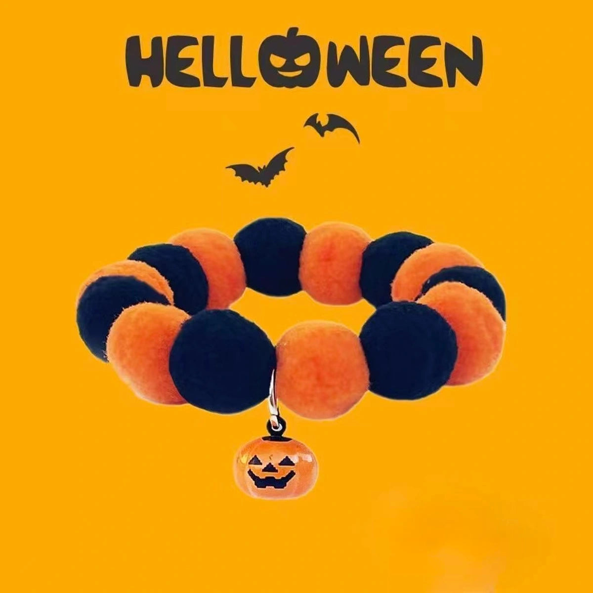 Pom-pom pet collar and pumpkin charm on orange background