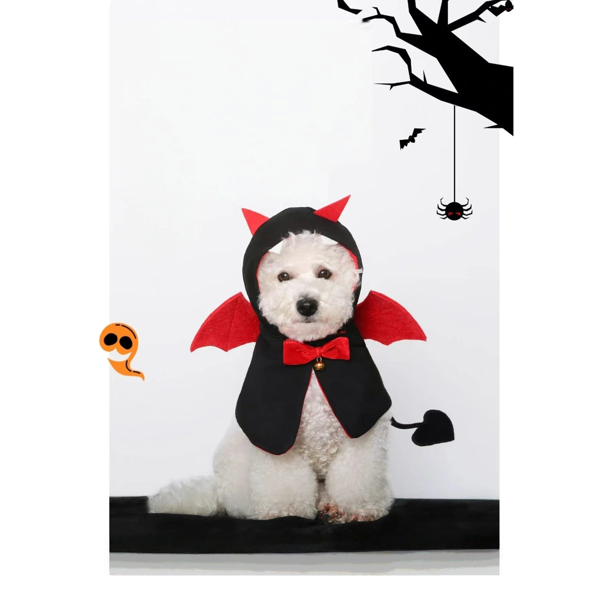 Small dog wearing the black and red devil cape