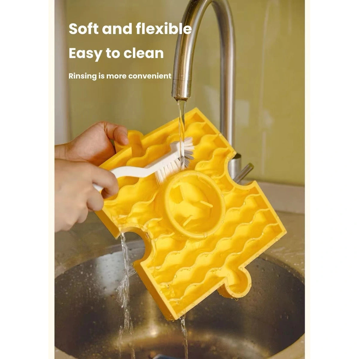 Yellow HOWGO silicone enrichment mat being washed under a tap