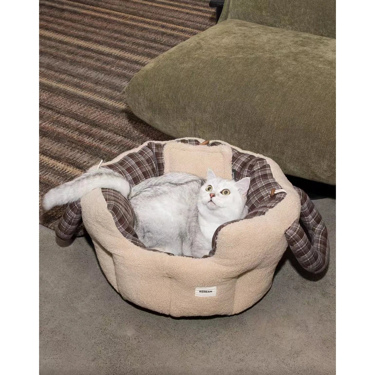 Cat curled up in the beige HiDREAM travel bed
