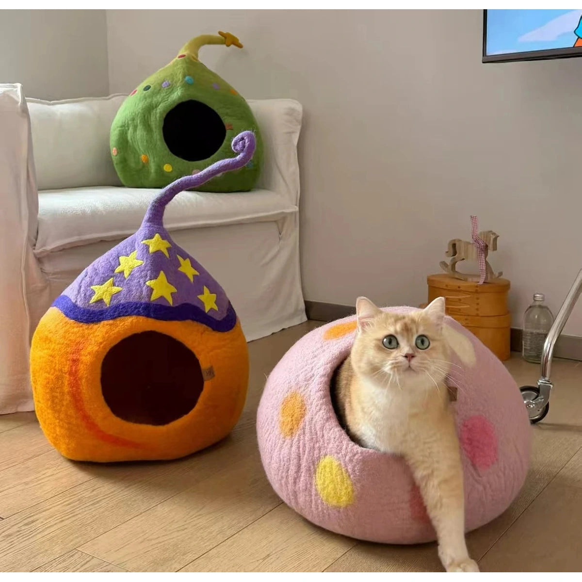 Cat standing beside a pink spotted Coni Life cat cave