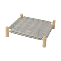 Raised pet cot with a grey woven surface and four wooden-look corner posts