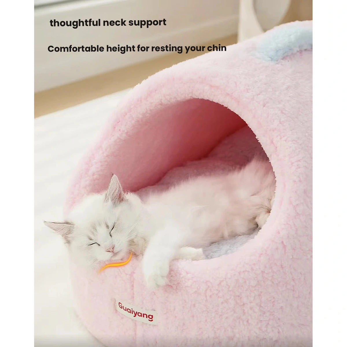 Cat resting its chin at the opening of a pink cave bed