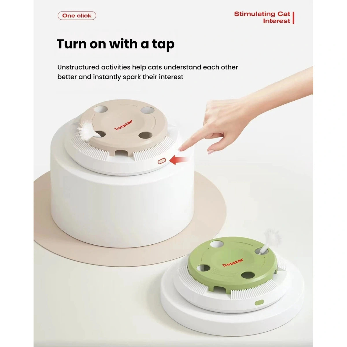 Hand pressing the start button on a beige Petstar cat toy beside the green version