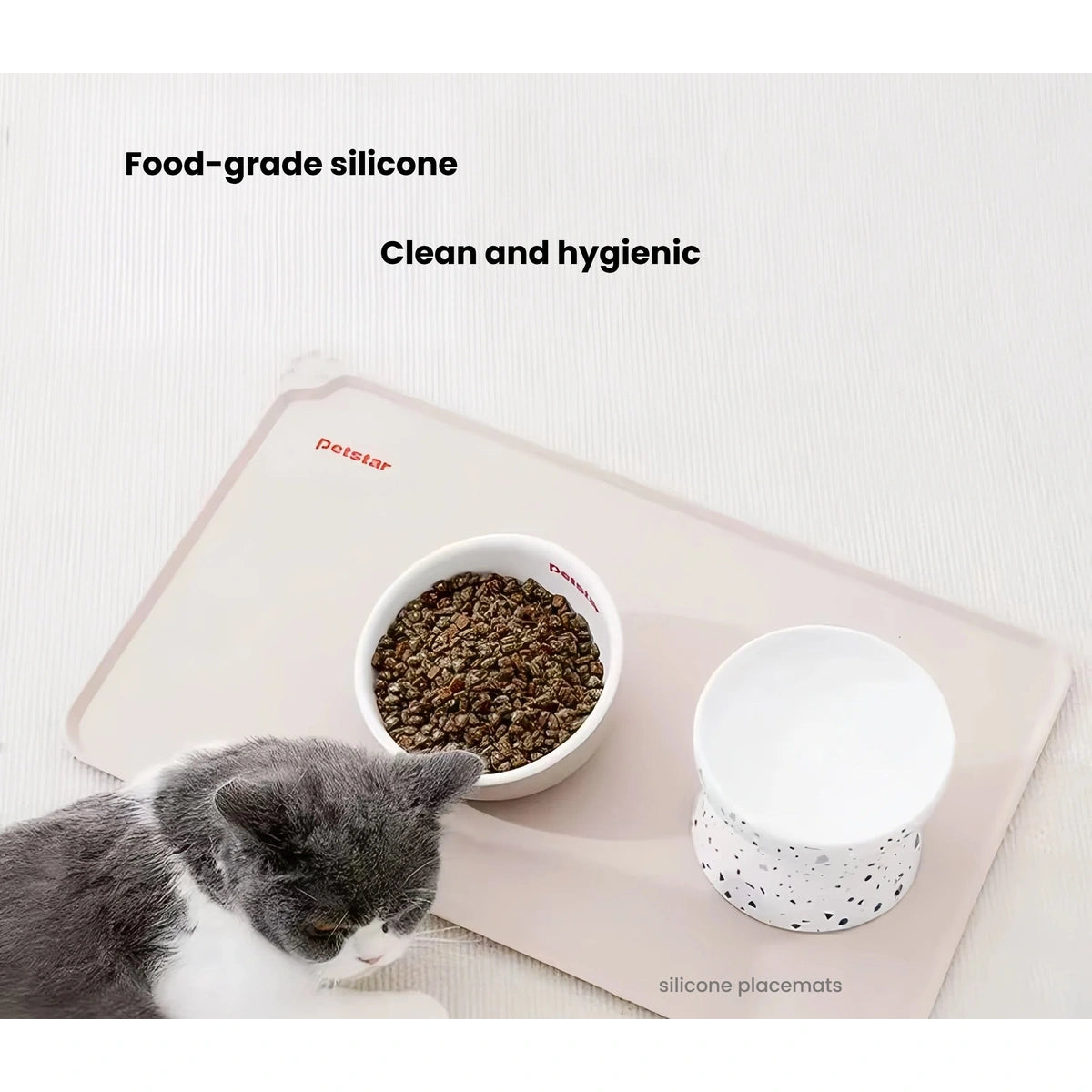 Overhead view of a cat and two feeding bowls on the Petstar mat