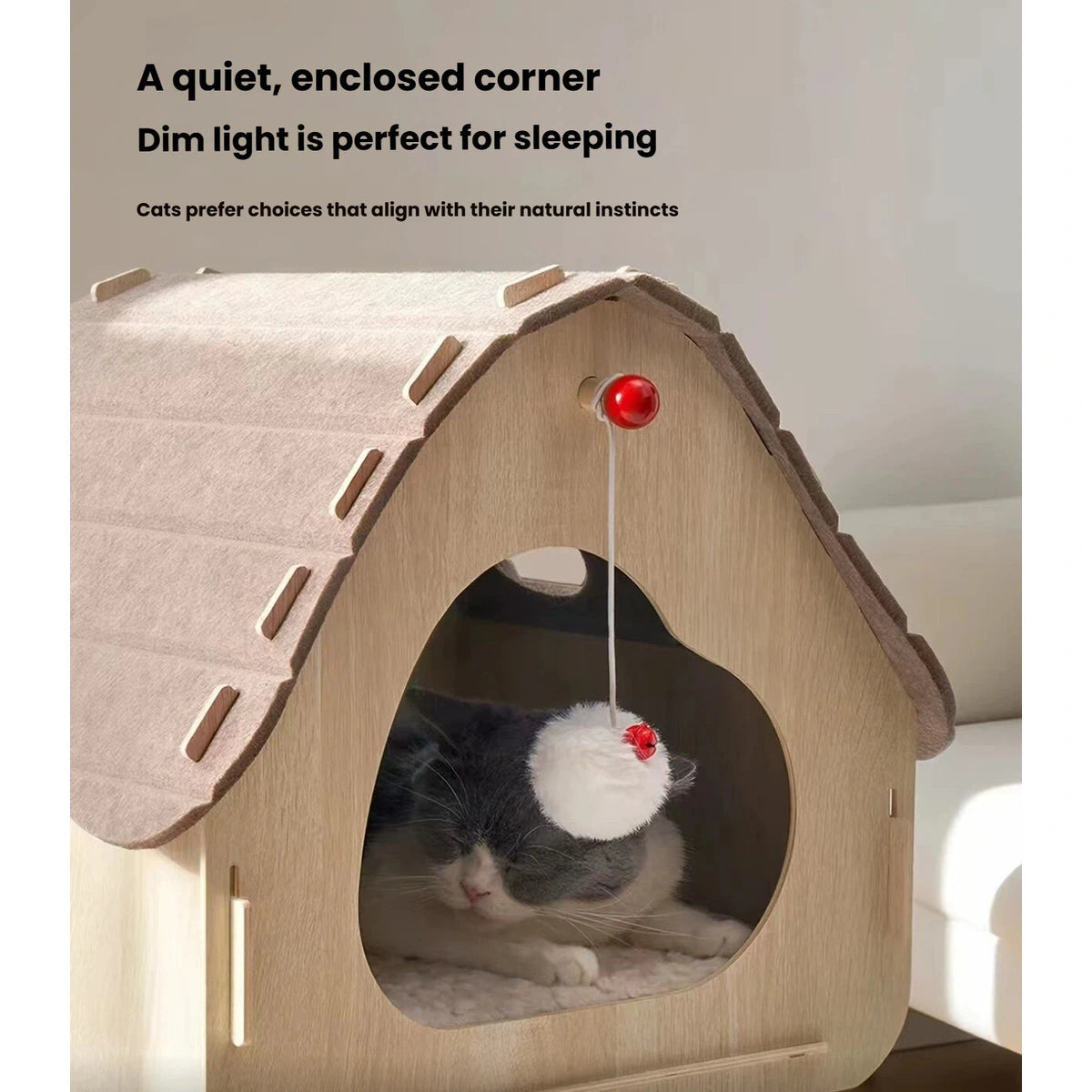 Cat resting inside the Petstar rooftop house with the hanging pom-pom below