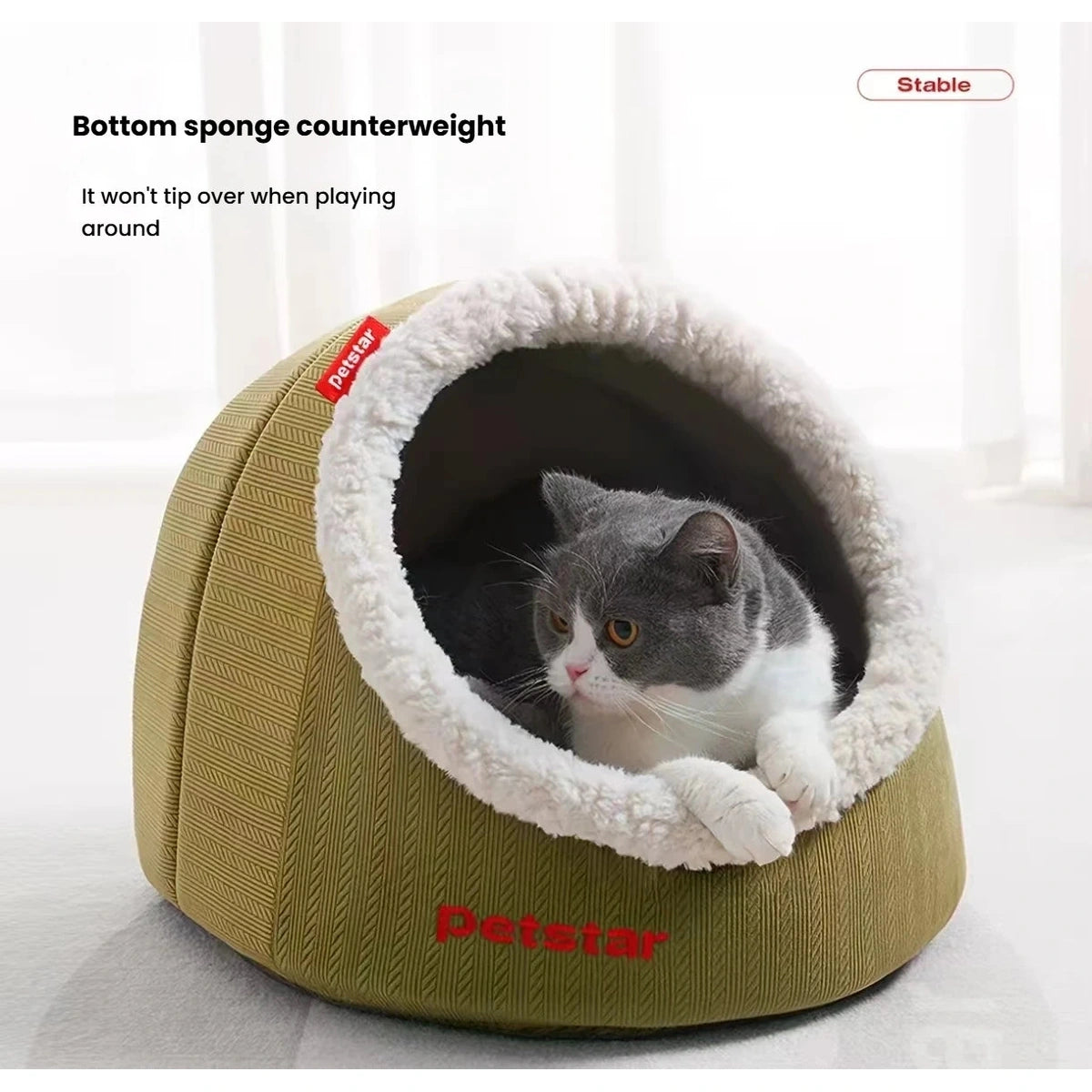 Cat looking out from the soft-lined entrance of a Petstar cave bed